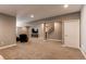 Spacious finished basement with ample seating, plush carpeting, and stairs to the upper level at 25144 E Archer Pl, Aurora, CO 80018