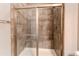 Modern bathroom shower with grey tiled surround, glass door, and built-in bench at 25144 E Archer Pl, Aurora, CO 80018