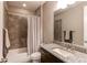 Well-lit bathroom featuring tile shower with curtain, granite vanity, and ample counter space at 25144 E Archer Pl, Aurora, CO 80018