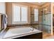Beautiful bathroom featuring a soaking tub with tile surround and a glass-enclosed shower at 25144 E Archer Pl, Aurora, CO 80018