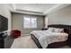 Comfortable main bedroom featuring a tray ceiling, plush bedding, and a cozy red accent chair at 25144 E Archer Pl, Aurora, CO 80018