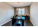 Inviting home office with dark wood floors, a chandelier, and ample natural light from the shuttered window at 25144 E Archer Pl, Aurora, CO 80018