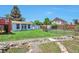 A well-maintained backyard features lush grass, stone path, sheds, and a wooden fence at 9135 W Maplewood Ave, Littleton, CO 80123