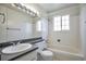 Bathroom featuring a tub, toilet, sink, large mirror, and natural light at 9135 W Maplewood Ave, Littleton, CO 80123