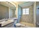 Bathroom with tiled shower stall, single sink vanity, and tiled walls at 9135 W Maplewood Ave, Littleton, CO 80123