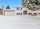 Charming two-story home with a two-car garage covered in snow at 9135 W Maplewood Ave, Littleton, CO 80123