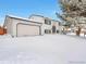 Charming two-story home with a two-car garage covered in snow at 9135 W Maplewood Ave, Littleton, CO 80123