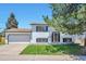 Split level home featuring a two car garage, front lawn and mature trees at 9135 W Maplewood Ave, Littleton, CO 80123