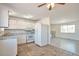 Kitchen features tiled flooring, white appliances, and a passthrough to the living room at 9135 W Maplewood Ave, Littleton, CO 80123
