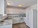 Well-lit kitchen with white appliances, granite countertops and tile floors at 9135 W Maplewood Ave, Littleton, CO 80123