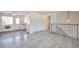 Open living room with light gray laminate flooring and staircase with decorative metal railing at 9135 W Maplewood Ave, Littleton, CO 80123