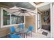 Charming back patio with outdoor dining set, umbrella, and easy access to the home's entrance and bicycle rack at 8095 E Colorado Ave # 5, Denver, CO 80231