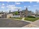 A wide exterior shot of a townhome with a garage, green lawn, white fence, and walkway at 8095 E Colorado Ave # 5, Denver, CO 80231