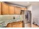 Charming kitchen featuring wood cabinets, granite counters, stainless steel appliances, and modern backsplash at 8095 E Colorado Ave # 5, Denver, CO 80231