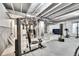 Basement featuring a home gym with weight machines, a treadmill, and exposed ceiling beams at 6801 S Valleyhead Ct, Aurora, CO 80016