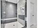 Modern bathroom shower featuring dark tiling, a built-in bench, and a partial glass enclosure at 6801 S Valleyhead Ct, Aurora, CO 80016