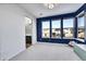 Bright bedroom featuring a blue accent wall, large windows offering ample natural light, and neutral carpeting at 6801 S Valleyhead Ct, Aurora, CO 80016