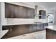 Modern kitchen featuring dark cabinetry, white countertops, and a stylish geometric tile backsplash at 6801 S Valleyhead Ct, Aurora, CO 80016