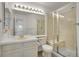 Bright bathroom with a glass-enclosed shower, neutral tile and a large mirror with vanity lighting at 740 Boxwood Ln, Longmont, CO 80503