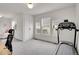 Spacious bonus room offers ample natural light, neutral carpeting, and a treadmill for exercise, promoting healthy living at 740 Boxwood Ln, Longmont, CO 80503