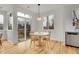 Sunny dining area with modern lighting, hardwood floors, and views of the backyard at 740 Boxwood Ln, Longmont, CO 80503