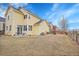 View of a sunny, yellow two-story home with fenced yard and lush green lawn at 740 Boxwood Ln, Longmont, CO 80503