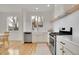 Well-lit kitchen with stainless steel appliances, white cabinets and a large window at 740 Boxwood Ln, Longmont, CO 80503