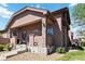 Inviting front porch with stone accents, covered entry, and well-maintained landscaping at 15501 E 112Th Ave # 20C, Commerce City, CO 80022