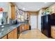 Charming kitchen featuring wood floors, granite countertops, wood cabinetry, and black appliances, all in a warm color scheme at 15501 E 112Th Ave # 20C, Commerce City, CO 80022