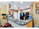 Inviting kitchen with granite counter, wood cabinetry, breakfast bar, and stainless steel appliances at 15501 E 112Th Ave # 20C, Commerce City, CO 80022