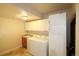 Bright laundry room with white appliances, storage cabinets, and a practical utility sink at 15501 E 112Th Ave # 20C, Commerce City, CO 80022