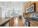 Well-lit kitchen featuring stainless steel appliances, a granite countertop, and a view into the living space at 13456 Via Varra # 211, Broomfield, CO 80020
