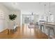 Open-concept living and dining area with hardwood floors, a modern ceiling fan, and a kitchen counter with stools at 13456 Via Varra # 211, Broomfield, CO 80020