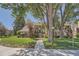 Inviting multi-level condo with landscaped grounds, mature trees, and a sidewalk leading to the entrance at 13704 E Lehigh Ave # D, Aurora, CO 80014