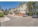 Well-maintained townhome with brick accents, a garage, and mature trees surrounding the property at 13704 E Lehigh Ave # D, Aurora, CO 80014