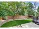 Landscaped backyard featuring decorative rocks, a lush lawn, mature trees, and a deck at 9737 Canberra Ct, Highlands Ranch, CO 80130