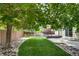 Serene backyard featuring a deck, a lush lawn, and decorative rock landscaping at 9737 Canberra Ct, Highlands Ranch, CO 80130