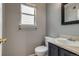 A simple bathroom featuring a toilet, sink, and a small window at 9737 Canberra Ct, Highlands Ranch, CO 80130
