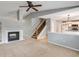 Open-concept living room with fireplace, stairway, and view into the kitchen for easy entertaining at 9737 Canberra Ct, Highlands Ranch, CO 80130