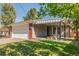 Exterior view of home showcasing covered porch, well-maintained lawn, and attached garage at 6490 E Dakota Ave, Denver, CO 80224