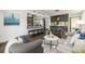 Open-concept living room with stylish seating, adjacent kitchen, and hardwood floors at 6490 E Dakota Ave, Denver, CO 80224