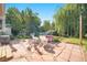A tranquil backyard featuring a stone patio, seating, lush greenery, and a whimsical playhouse at 6248 W 75Th, Arvada, CO 80003