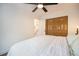 A cozy bedroom featuring a bed, a ceiling fan, and a closet with wood doors at 6248 W 75Th, Arvada, CO 80003