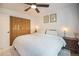 A cozy bedroom featuring a bed, a ceiling fan, and a closet with wood doors at 6248 W 75Th, Arvada, CO 80003