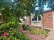 Charming brick home with a well-manicured front yard, blooming flowers, and a quaint brick walkway at 6248 W 75Th, Arvada, CO 80003