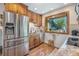 Bright kitchen with wood cabinets, stainless steel fridge, and view of backyard at 6248 W 75Th, Arvada, CO 80003