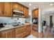 Kitchen with wood cabinets, granite counters and stainless steel appliances open to the living room at 6248 W 75Th, Arvada, CO 80003