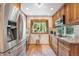 Bright kitchen with stainless steel appliances, view of backyard and wood cabinets at 6248 W 75Th, Arvada, CO 80003