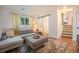 Bright living room featuring a comfortable sectional sofa, stylish decor, and easy access to the bathroom and stairs at 6248 W 75Th, Arvada, CO 80003