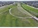 Aerial view of a green space with walking path and the surrounding community and city at 5434 N Xenia St, Denver, CO 80238